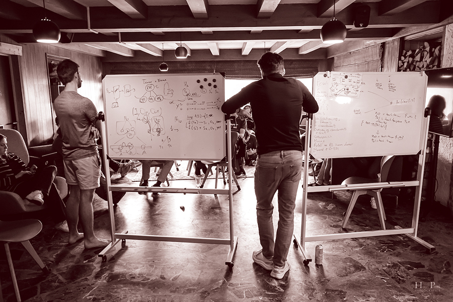 Team members collaborating around whiteboards at an offsite.